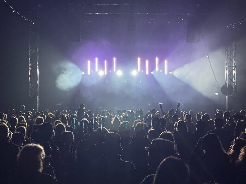 Festival crowd watching a live performance with stage lighting and effects at Underneath the Stars Festival in Barnsley, produced by AYRE Event Solutions.